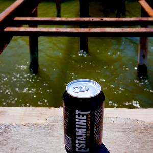 UNe canette de bière Estaminet posée sur une plance en bois devant un pont en métal - France  - collection de photos clin d'oeil, catégorie clindoeil